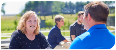 two employees siting outside the office.