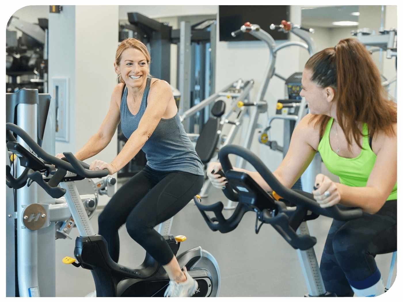 Two employee exercise on stationary bikes.