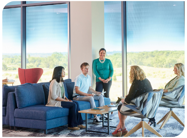 A group of employees meet in a common area.