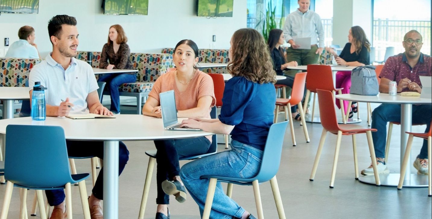 A group of Sammons Financial Group employees mingle in the office cafe